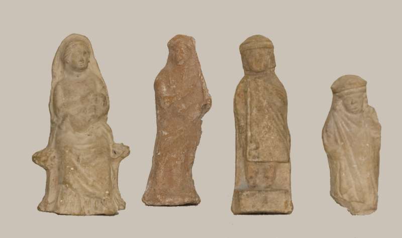 Cultic figurines: a woman holding an infant, a woman playing a lyre, a youth, and a chubby child